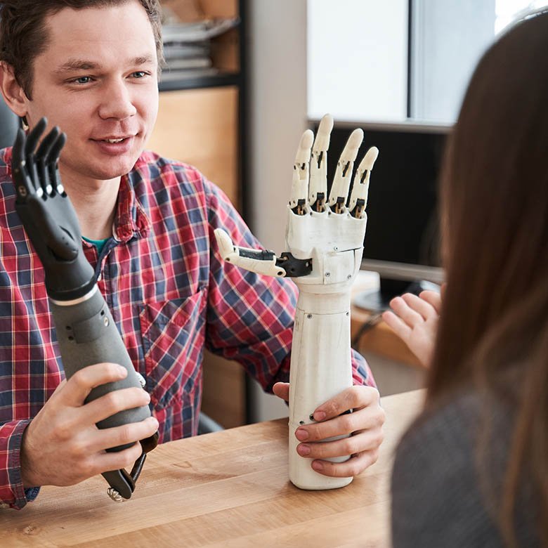 Male,Engineer,Holding,Two,Examples,Of,The,Prosthesis,Hands,And